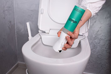 Djini Sprühflasche in der Anwendung um eine Toilette zu putzen